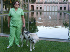 foto da Ethel e o co guia Gem num gramado em frente ao lago com cisnes brancos no ptio interno do palcio itamaraty no rio de janeiro