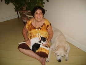 foto: Ethel sentada no cho da sala com Gem ao lado e as gatinhas Joy e Jully em seu colo.